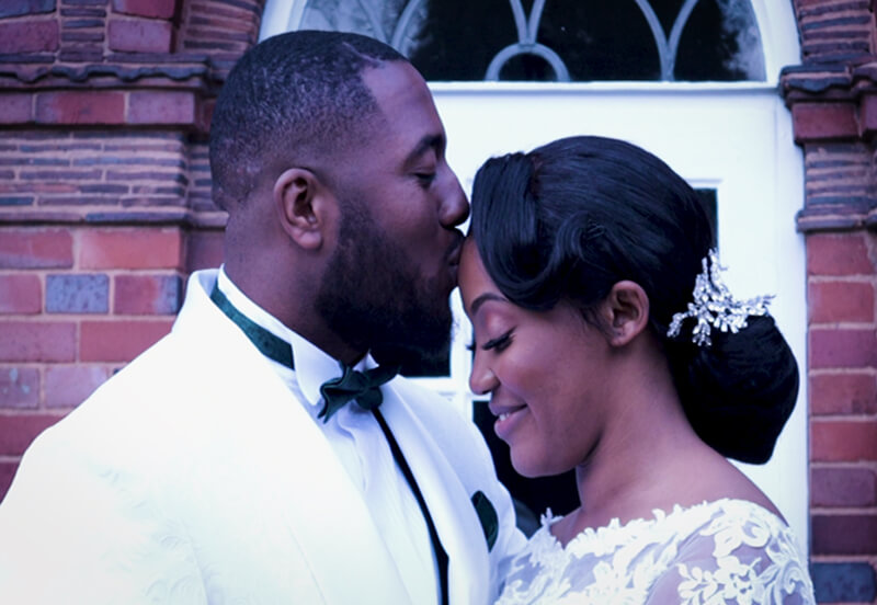 husband kissing new wife black wedding couple